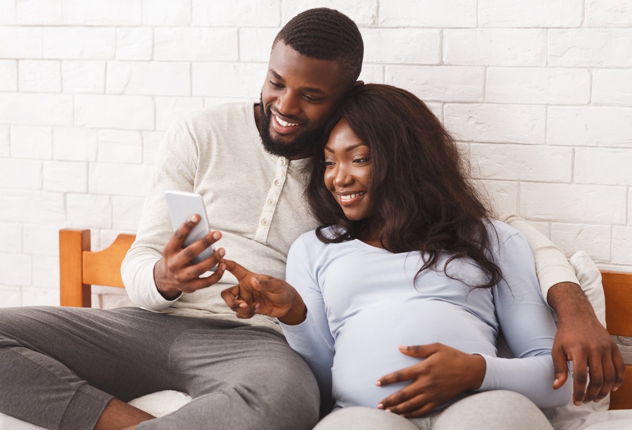 pregnant couple looking at mobile phone
