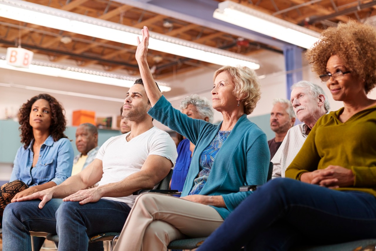 Woman raising hand in audience