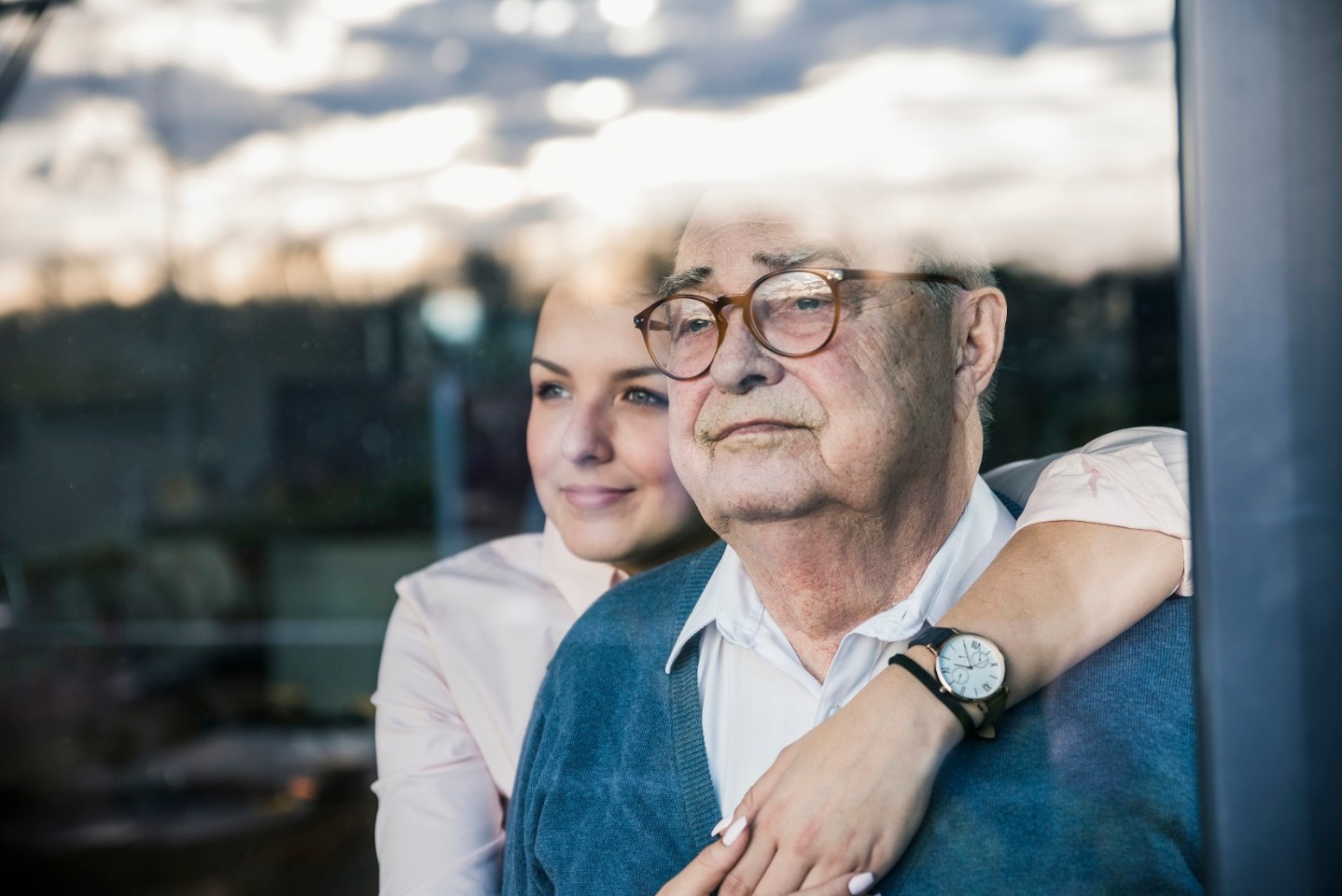 Daughter comforting dad looking out 