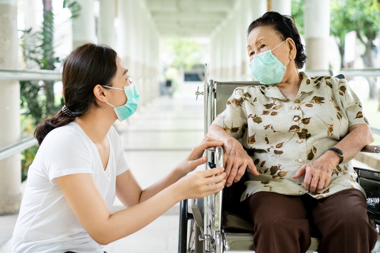 Nurse comforting patient in wheelchair