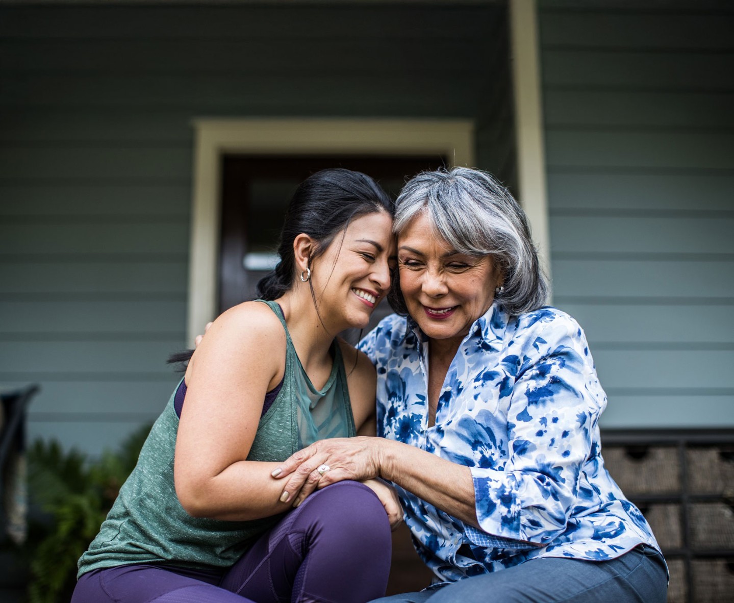 Two women smiling with heads together