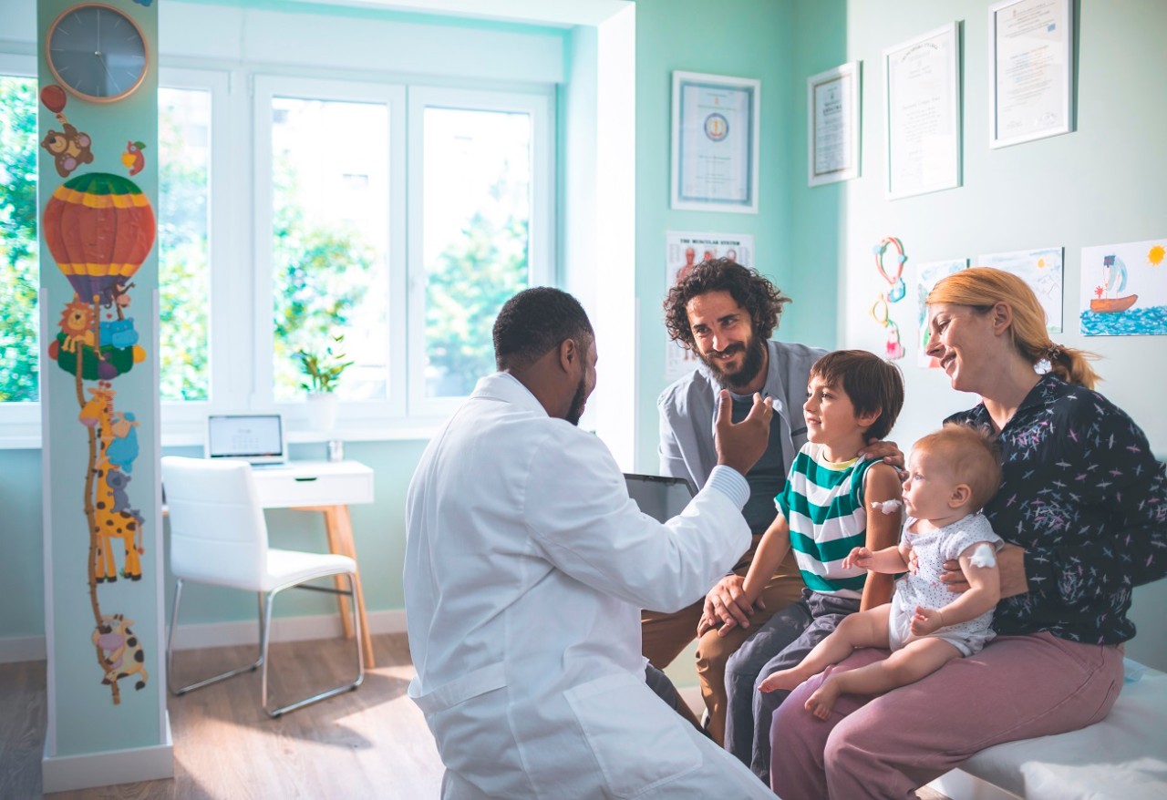 Doctor treating young patient with family