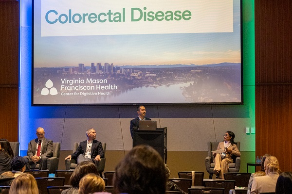 Digestive Health Symposium 2025 speaker with panel around him